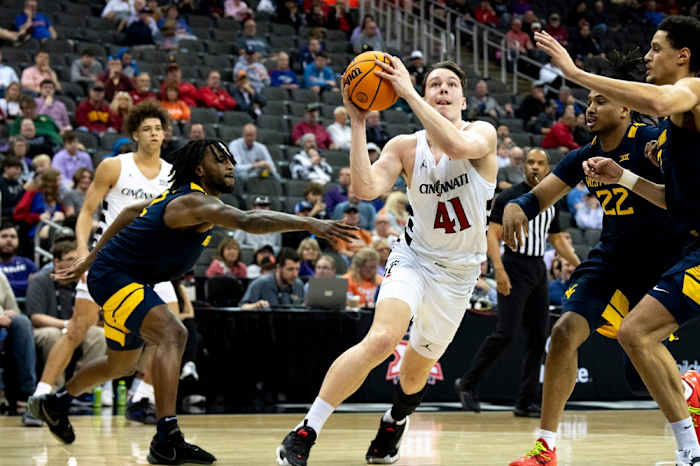 Cincinnati Bearcats guard Simas Lukosius (41) drives to the basket between West Virginia Mountaineers defenders in the first half of the Big 12 Conference tournament between Cincinnati Bearcats and West Virginia Mountaineers at T-Mobile Center in Kansas City, Mo., on Tuesday, March 12, 2024.